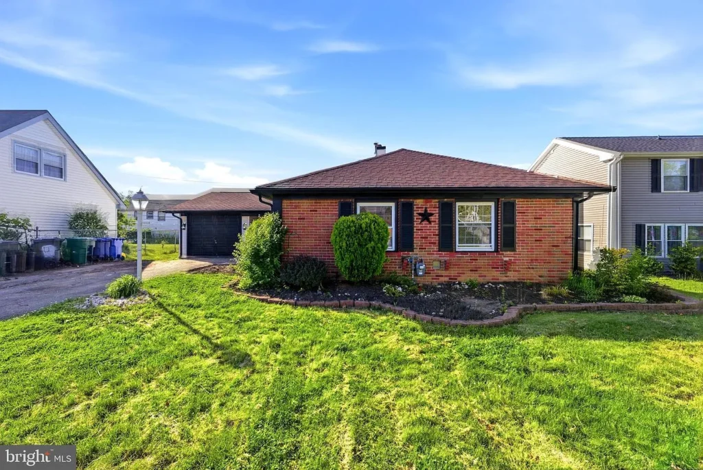 Exterior view of a staged 3-bedroom brick ranch home in Willingboro NJ with a front lawn, driveway, and single-car garage.