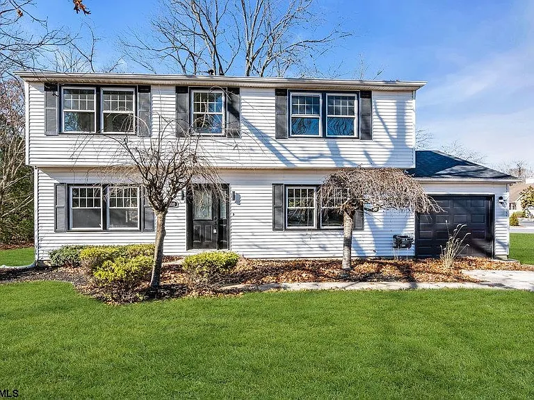 Exterior of a staged 4-bedroom Colonial home in Vineland NJ with white siding, black shutters, front lawn, garage, and landscaped yard.