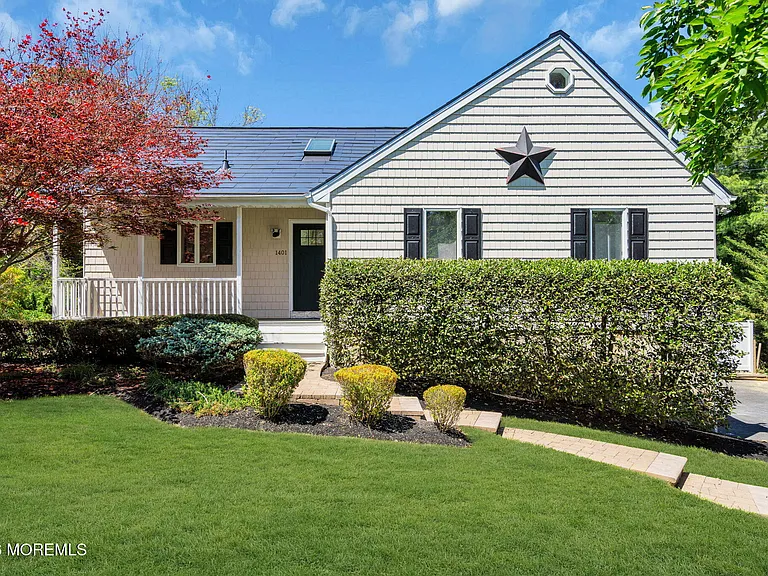Exterior of a staged 4-bedroom Pine Lake Park home in Toms River NJ with landscaped front yard, white siding, black shutters, and mature greenery.